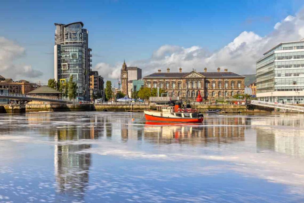 red and white boat on the water in front of customs house in belfast, northern ireland on a sunny day