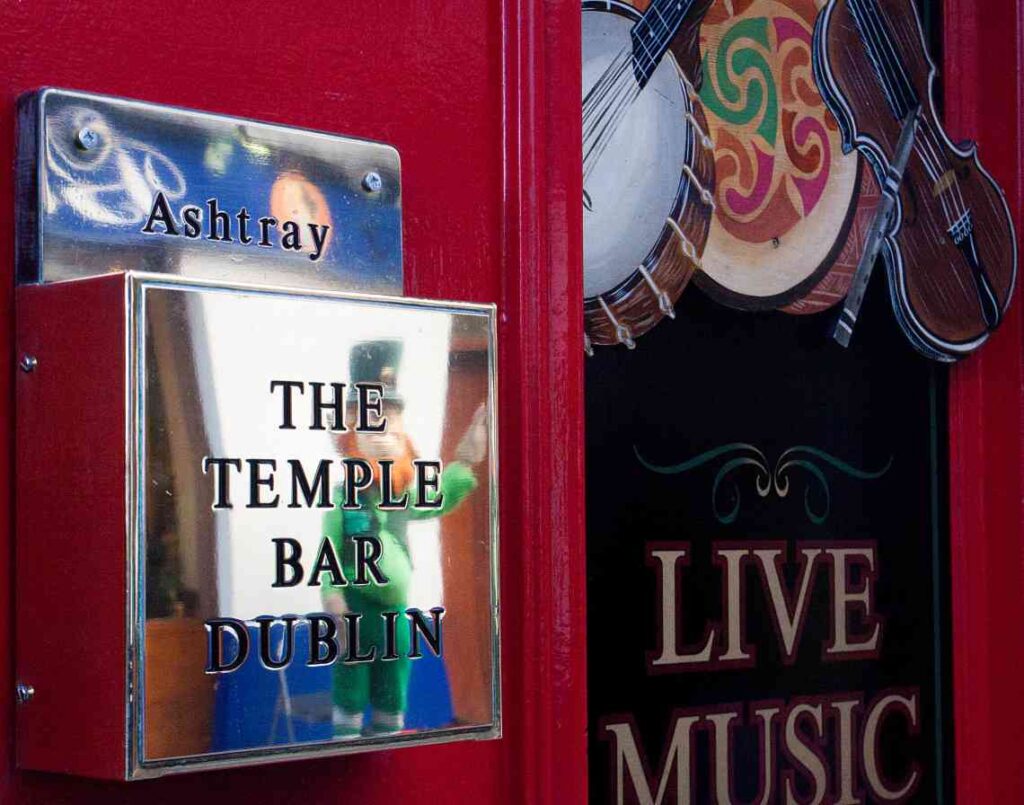 shiny metal sign for the temple bar dublin with musical instruments hanging in the window
