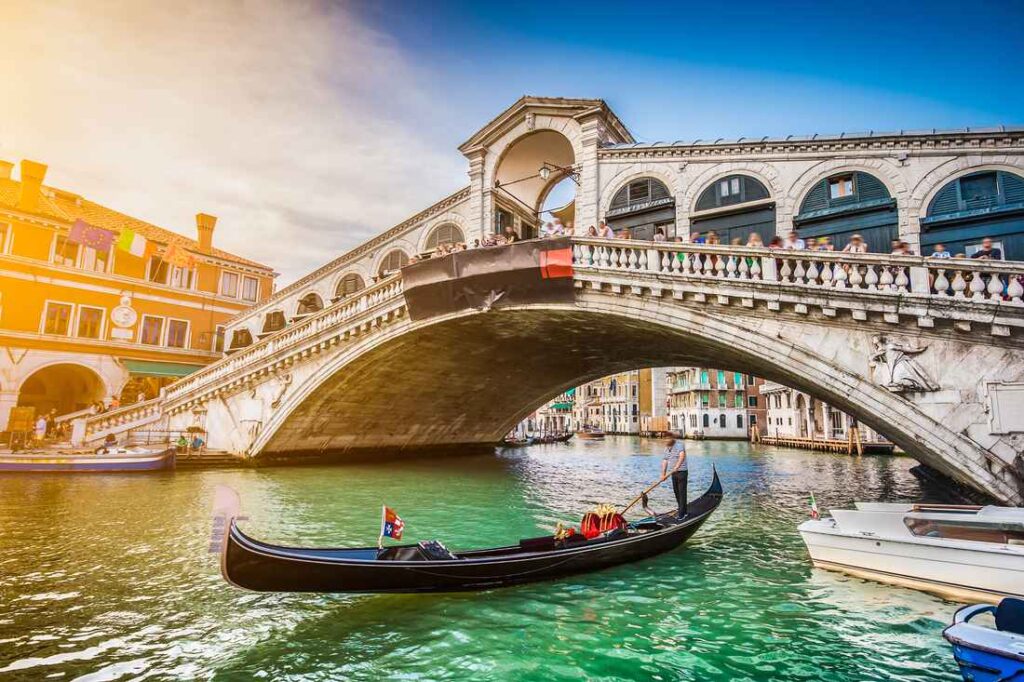 view of the white stone rialto bridge from the grand canal