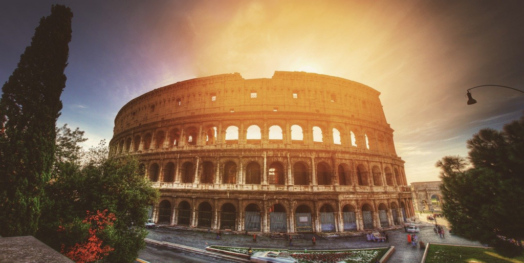 round ruins of the colosseum in rome at sunset