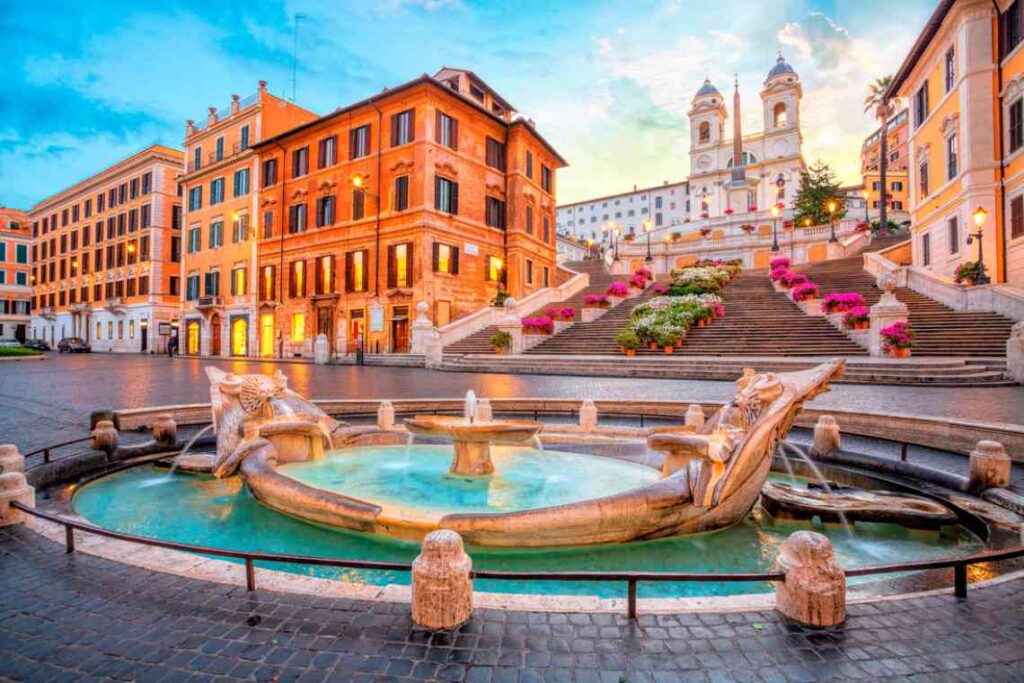 stone fountain with green water with stairs rising behind it in a piazza in rome.