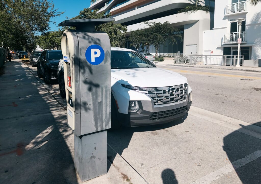 A car parked on the side of the street next to a parking meter in Miami.