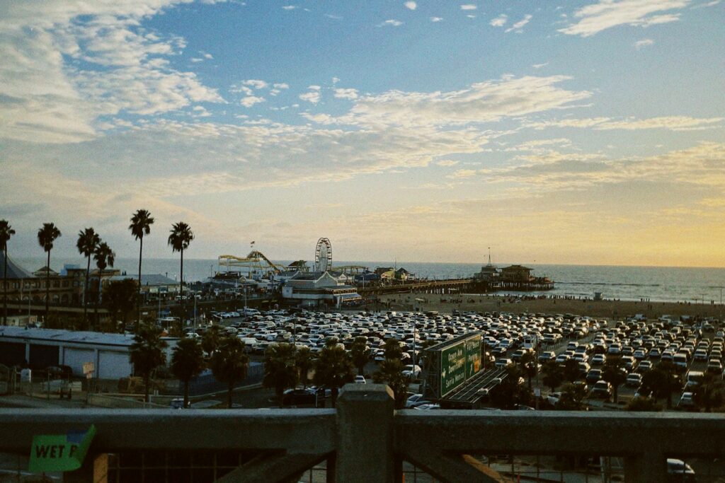 An aerial view of a parking lot with a view of Santa Monica State Beach in the back.