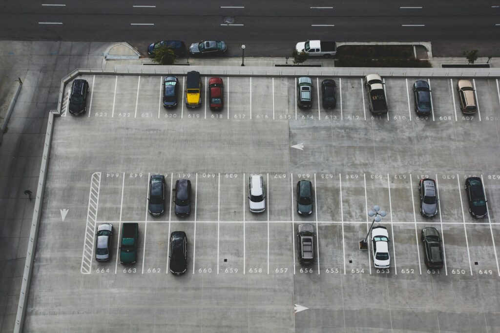 An aerial image of an open parking garage with parked cars and free spaces.