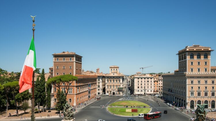 Italian flag on a pole flying in a city street in Rome, Italy.