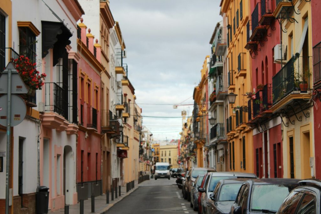 Cars parked on the side of the road during daytime in Sevilla, Spain.