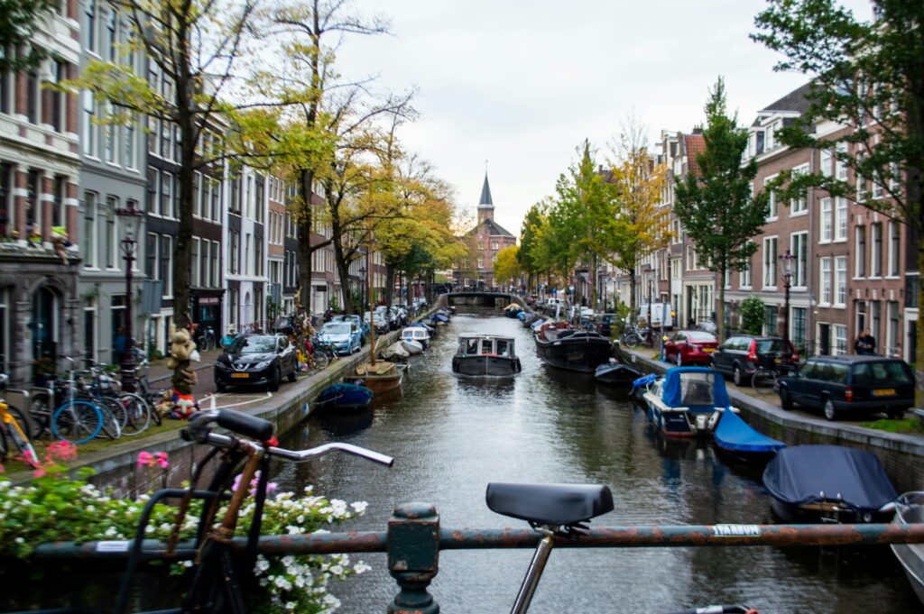 Boats docked along a seaside promenade in between buildings.