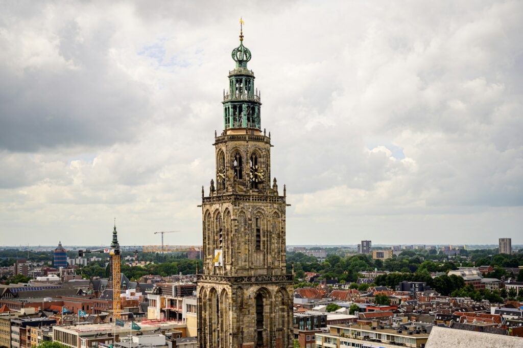 A tall stone clock tower in Groningen, Netherlands.