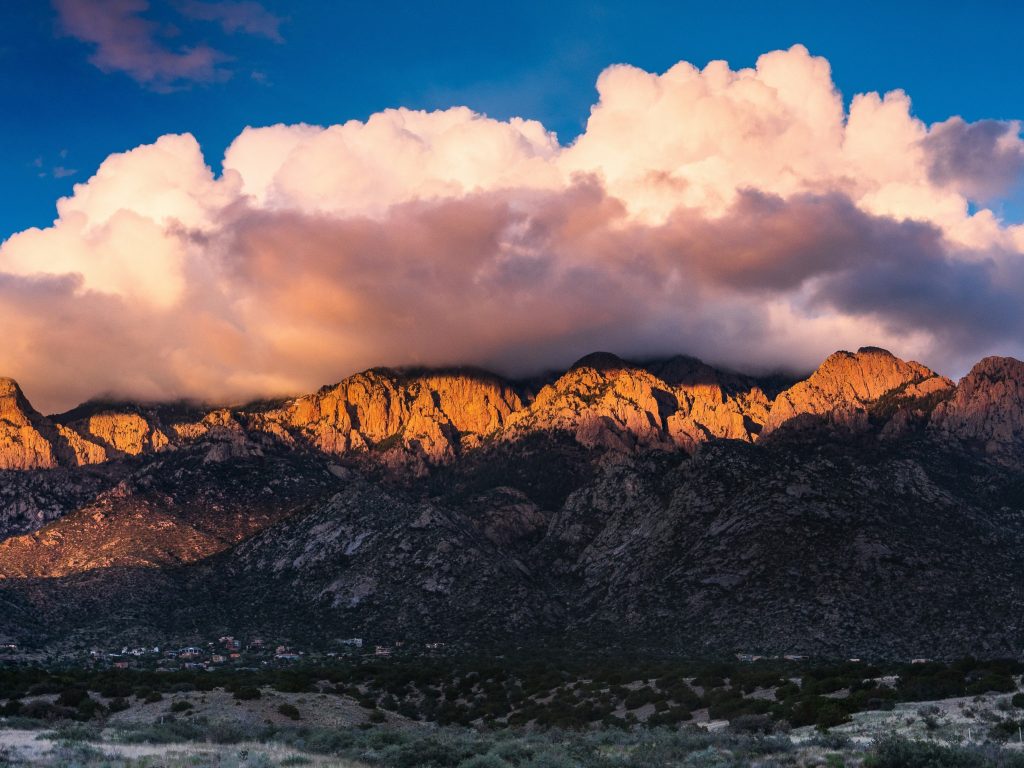 The Sandia Mountains glowing at sunset under dramatic clouds near Albuquerque, New Mexico.