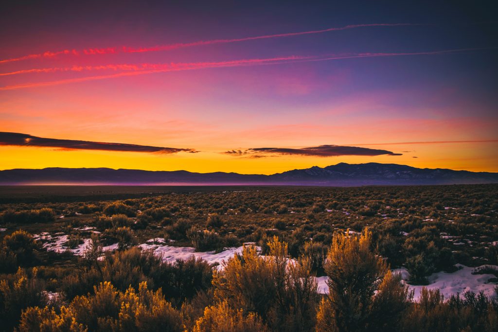 A vibrant sunset over the desert landscape of New Mexico.