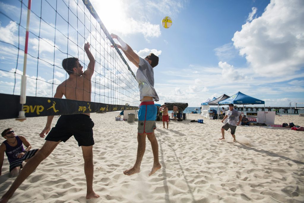 People playing volleyball on the sandy shores of Pompano Beach, Florida.