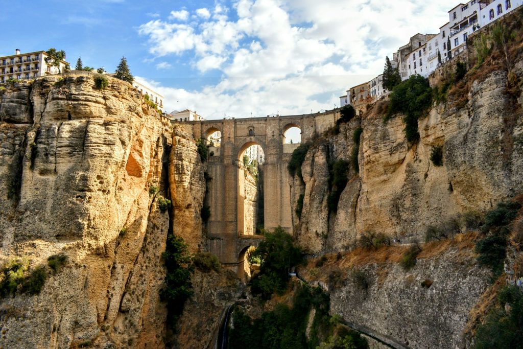 Puente Nuevo bridge spanning the dramatic El Tajo gorge in Ronda with white buildings on the clifftop. 