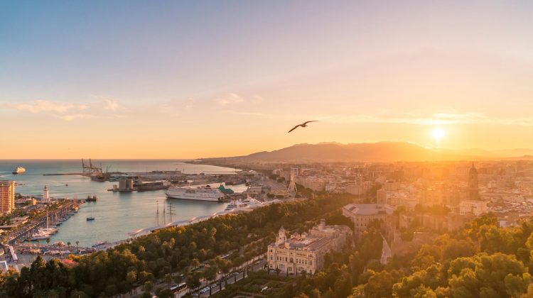 Aerial sunset view of Málaga with its port, city center and mountains in the background.